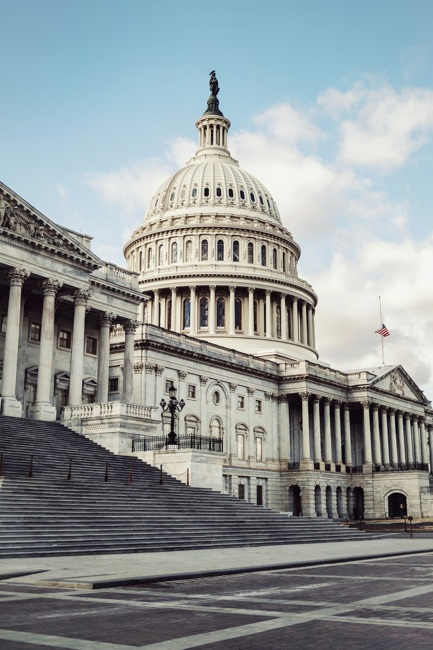 United States Capitol dome and marble steps under a pale sky
