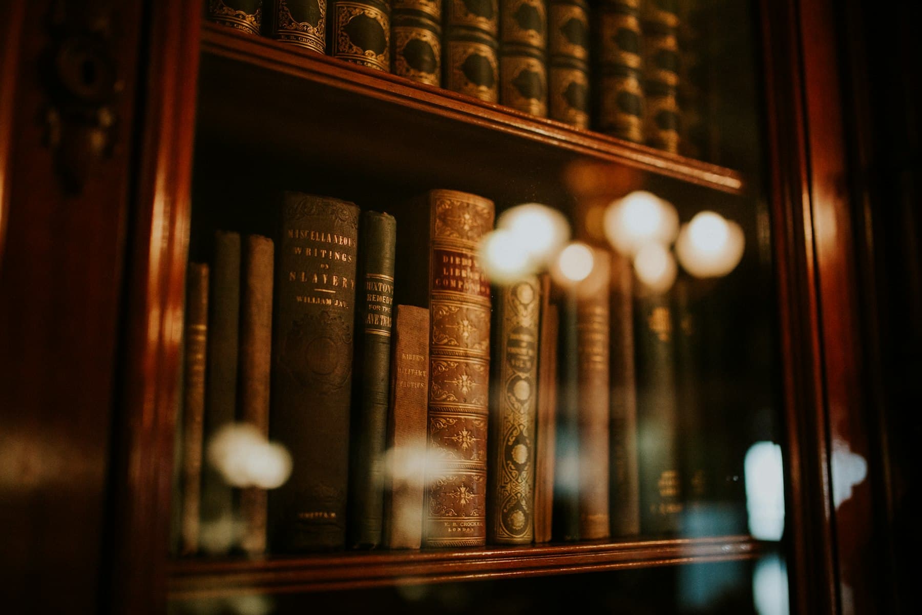 Gold-lettered leather law books behind cabinet glass